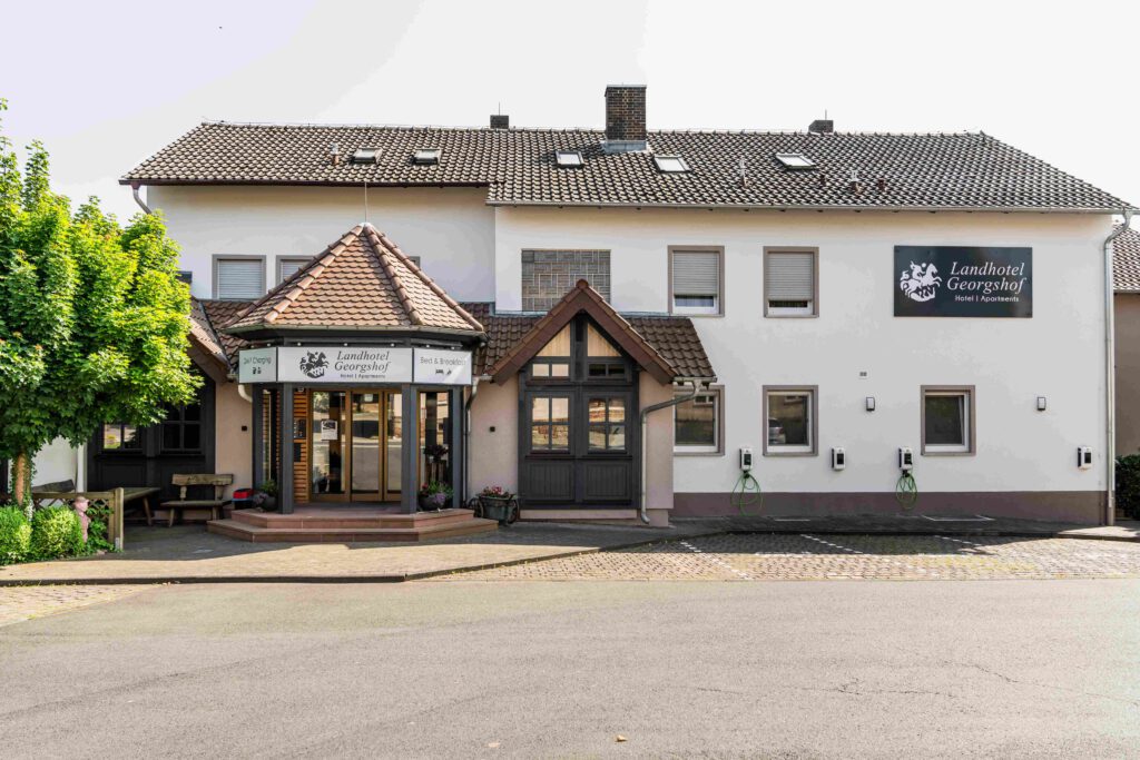 Frontansicht Hotel Hünfeld, großer Parkplatz, Elektroladepunkte. Bed&Breakfast